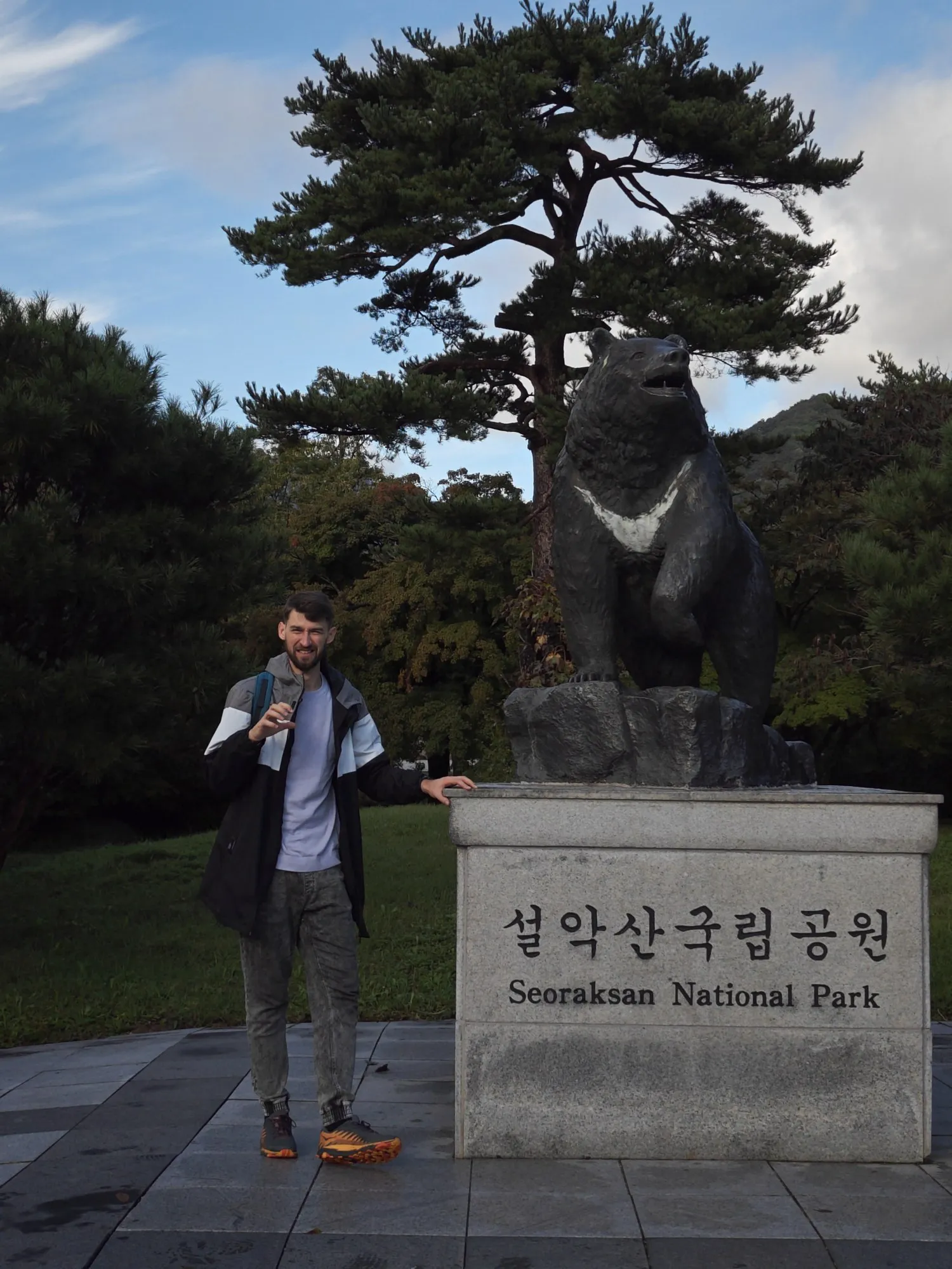 Aleksei standing next to a bronze bear statue at the entrance of Seoraksan National Park, South Korea